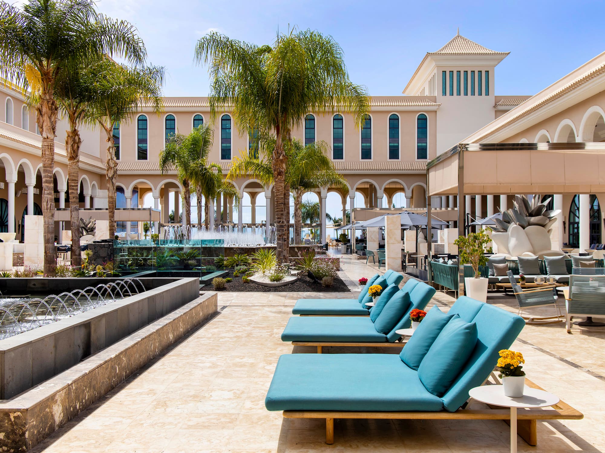 a pool area with chairs and palm trees