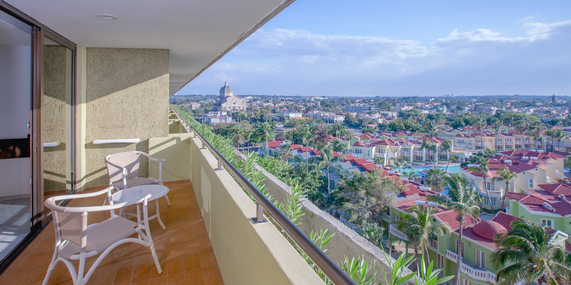 a balcony with chairs and a view of a city