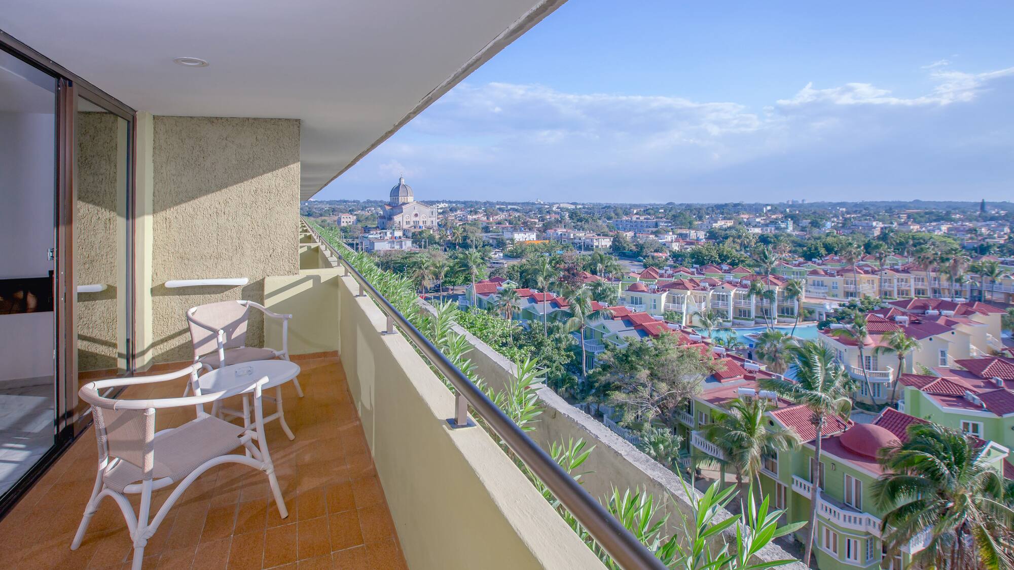 a balcony with chairs and a view of a city