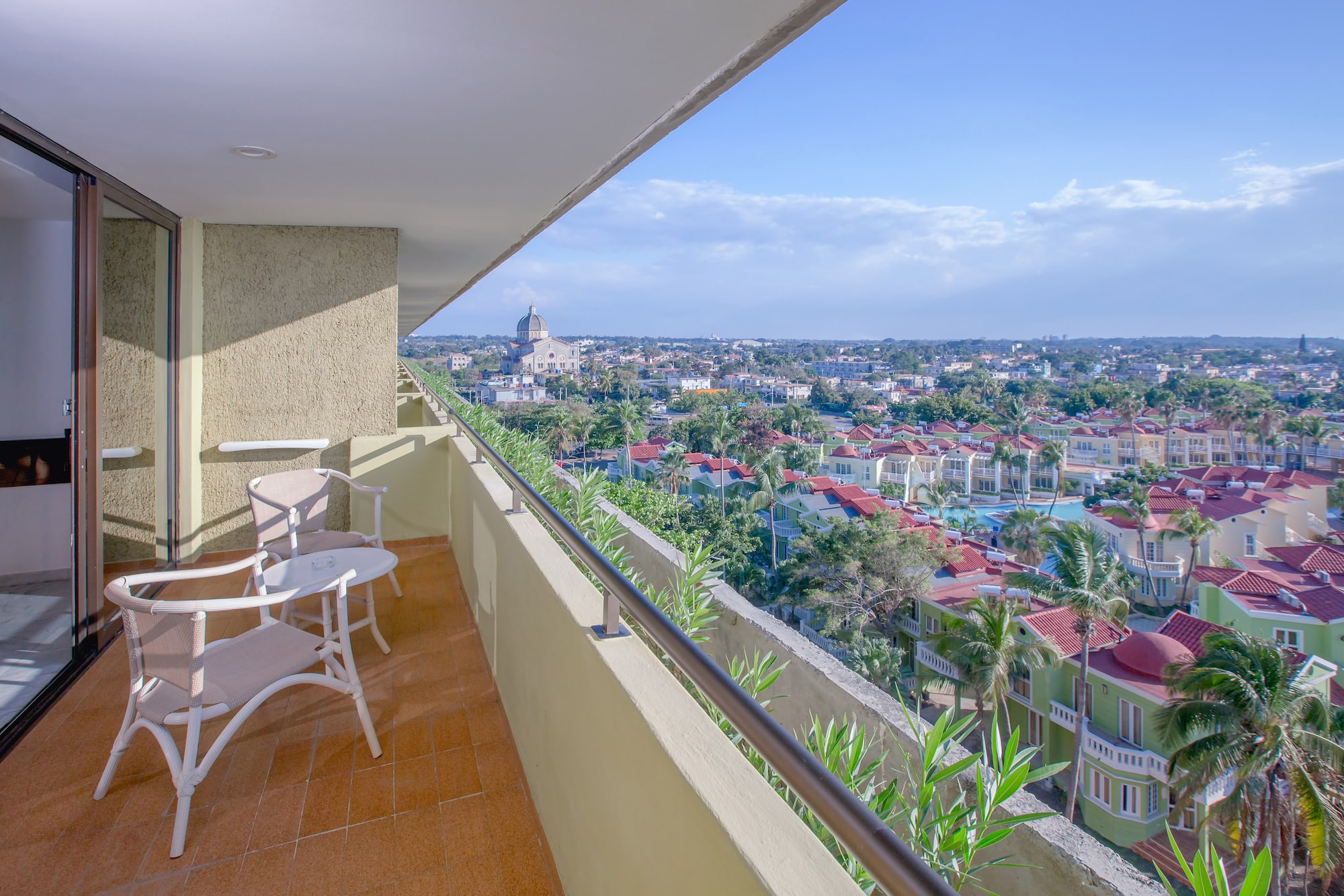 a balcony with chairs and a view of a city