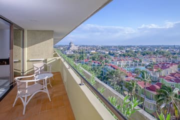 a balcony with chairs and a view of a city