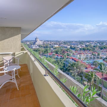 a balcony with chairs and a view of a city