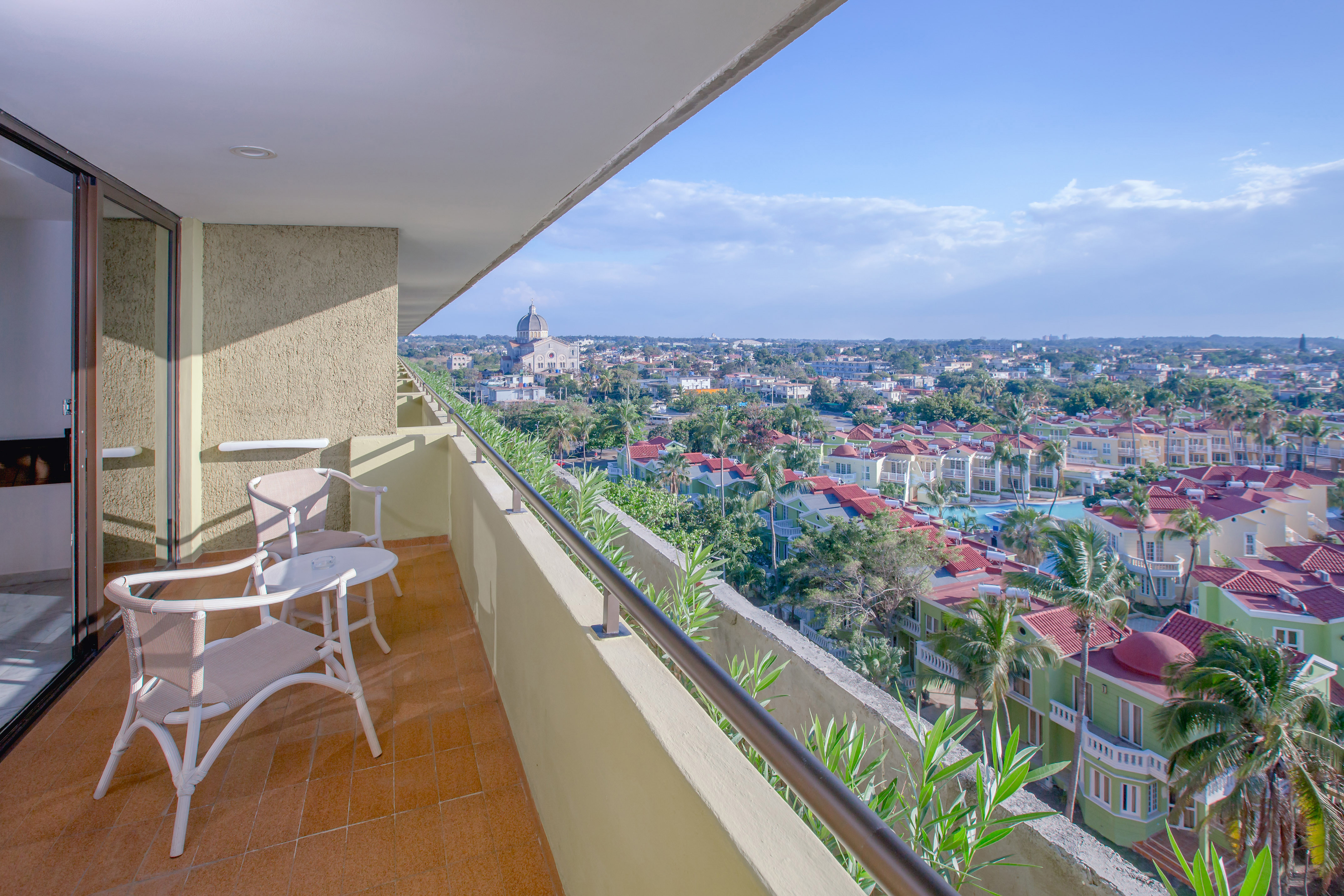 a balcony with chairs and a view of a city