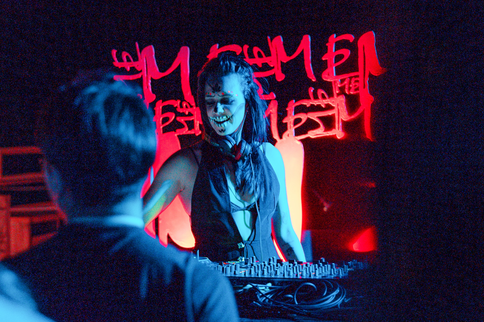 a woman with face paint on her face and a man standing behind a table