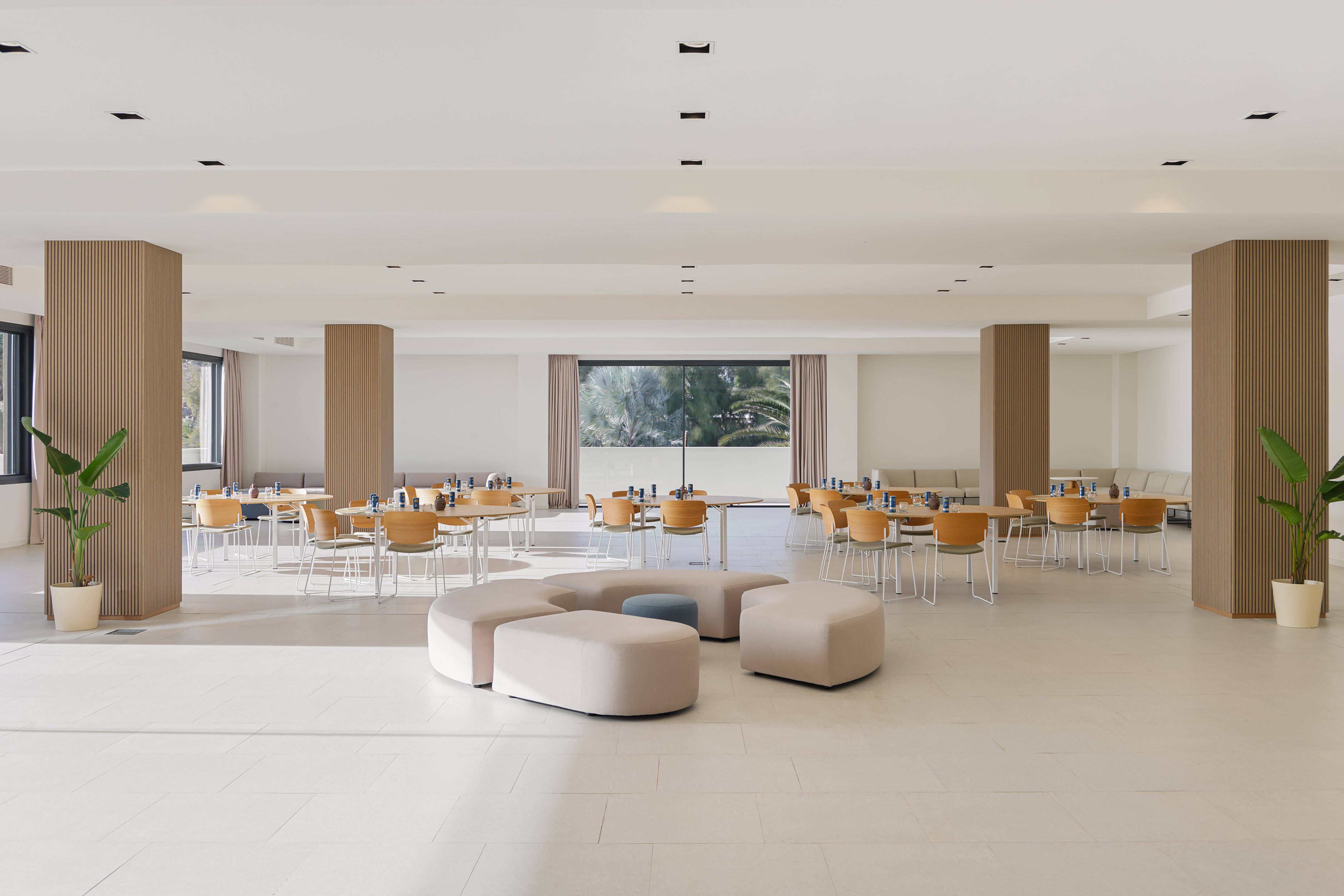 Modern hotel restaurant interior with dining tables and modular lounge seating.