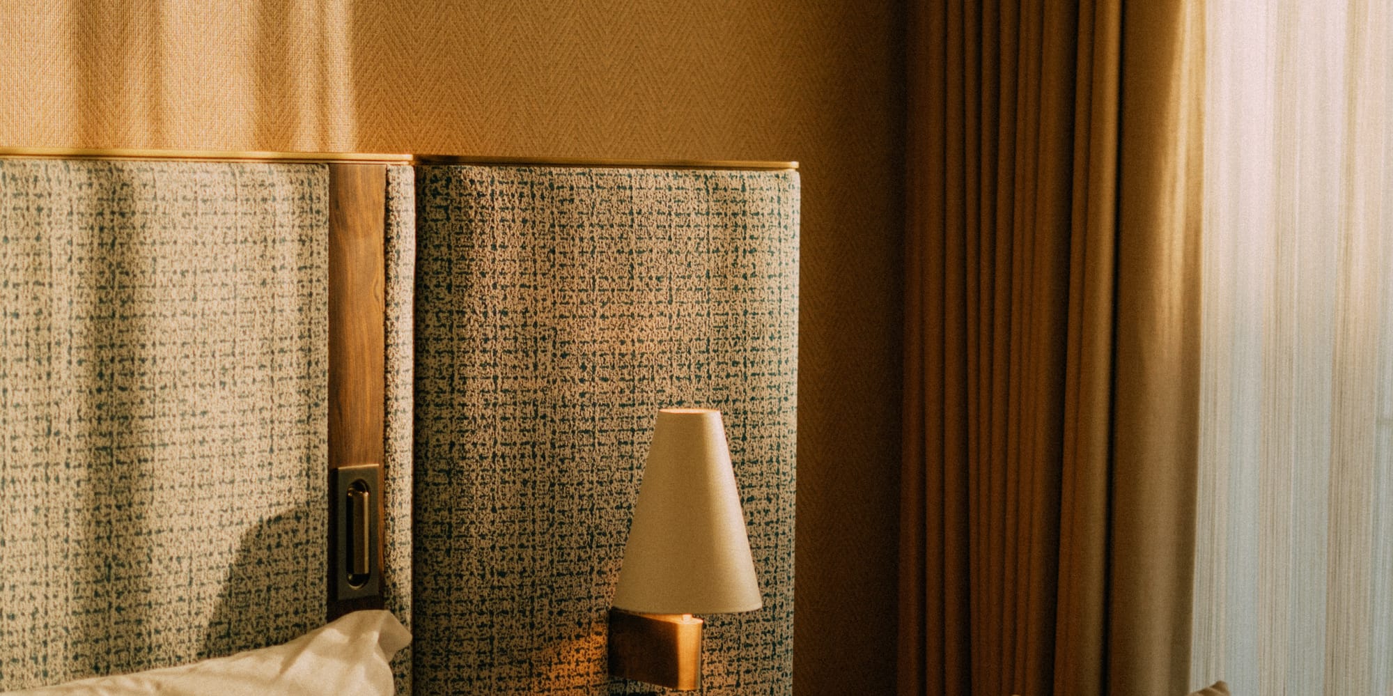 a bed with a lamp next to a chair