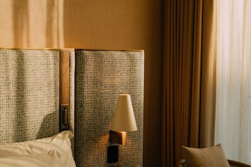 a bed with a lamp next to a chair