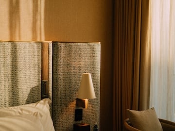 a bed with a lamp next to a chair