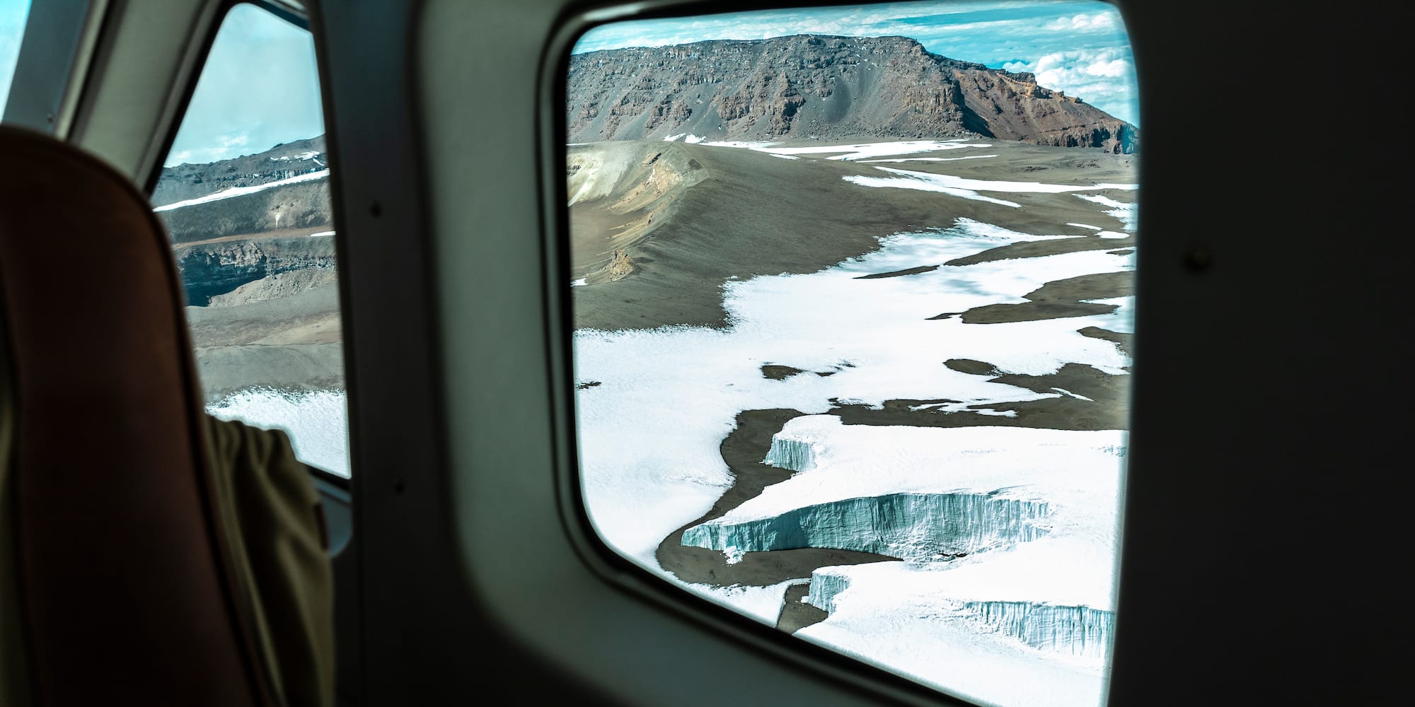 a view of snow and mountains from a plane window