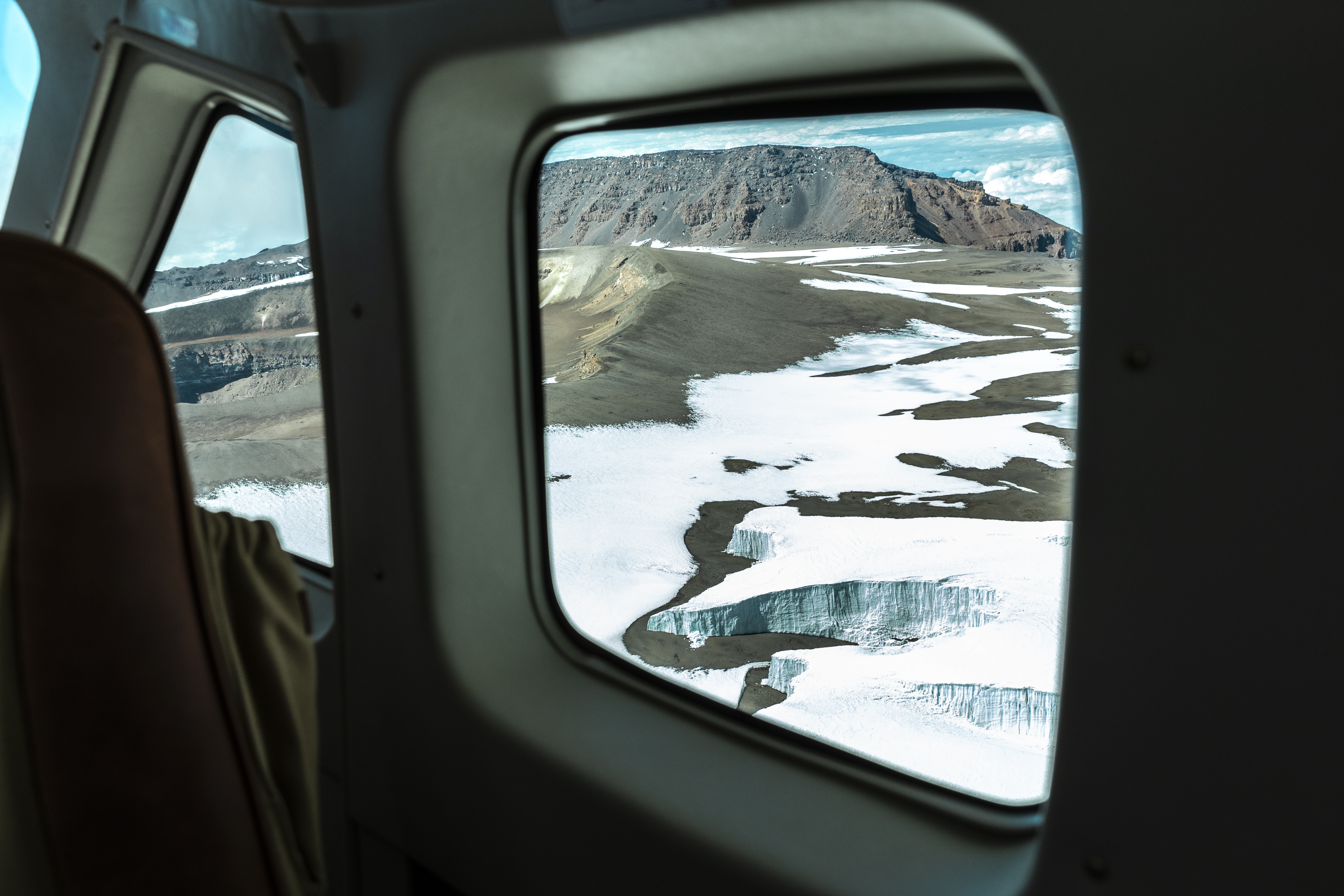 a view of snow and mountains from a plane window