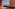 Terracotta balcony with ocean view, rattan furniture, and resort building.