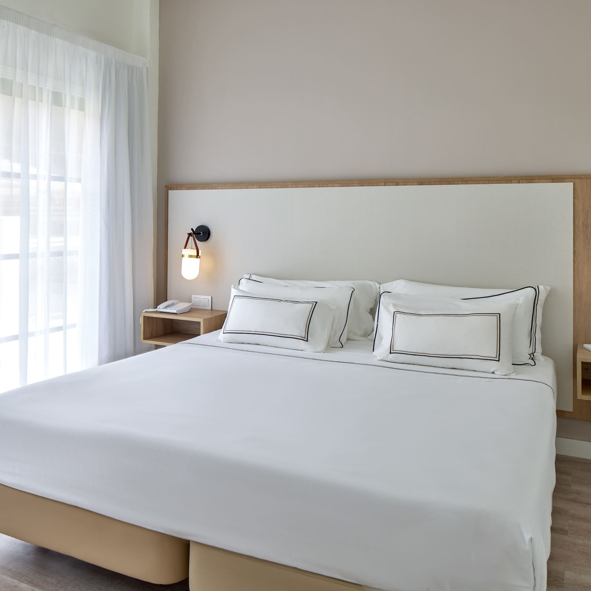 a bed with white sheets and a lamp