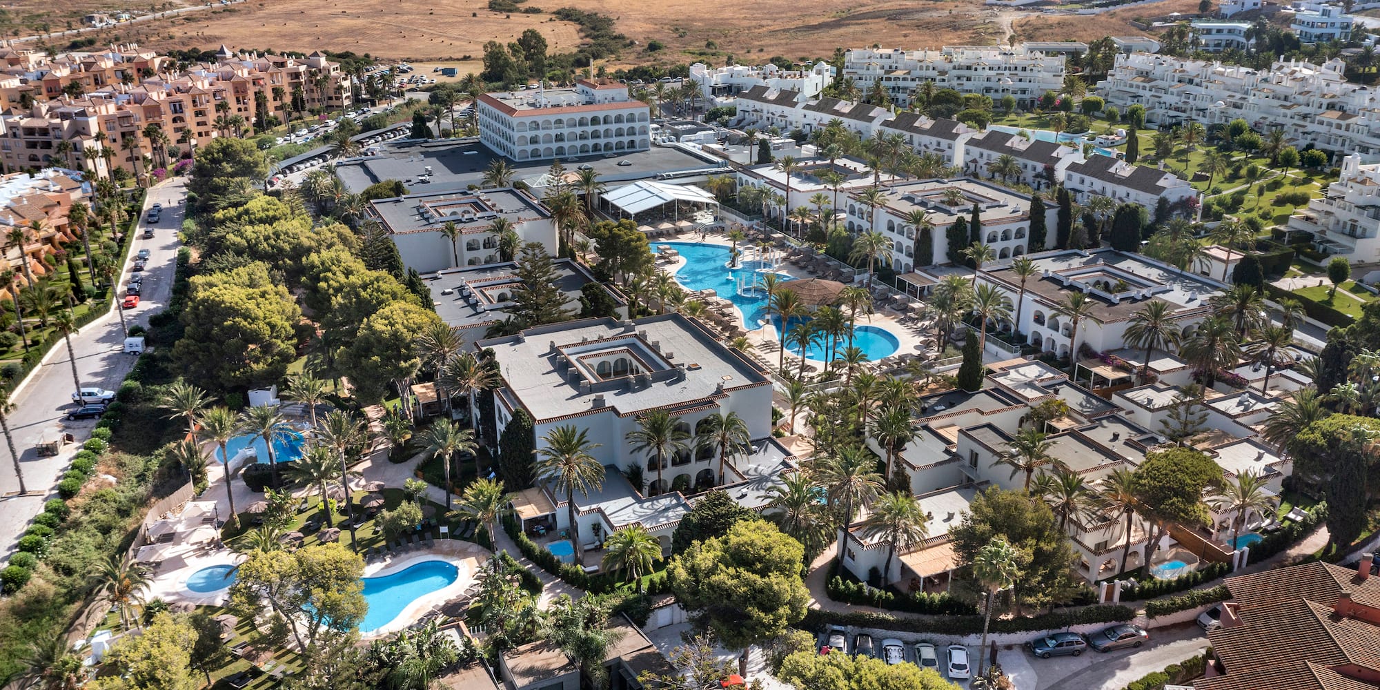 a aerial view of a resort with swimming pools and trees