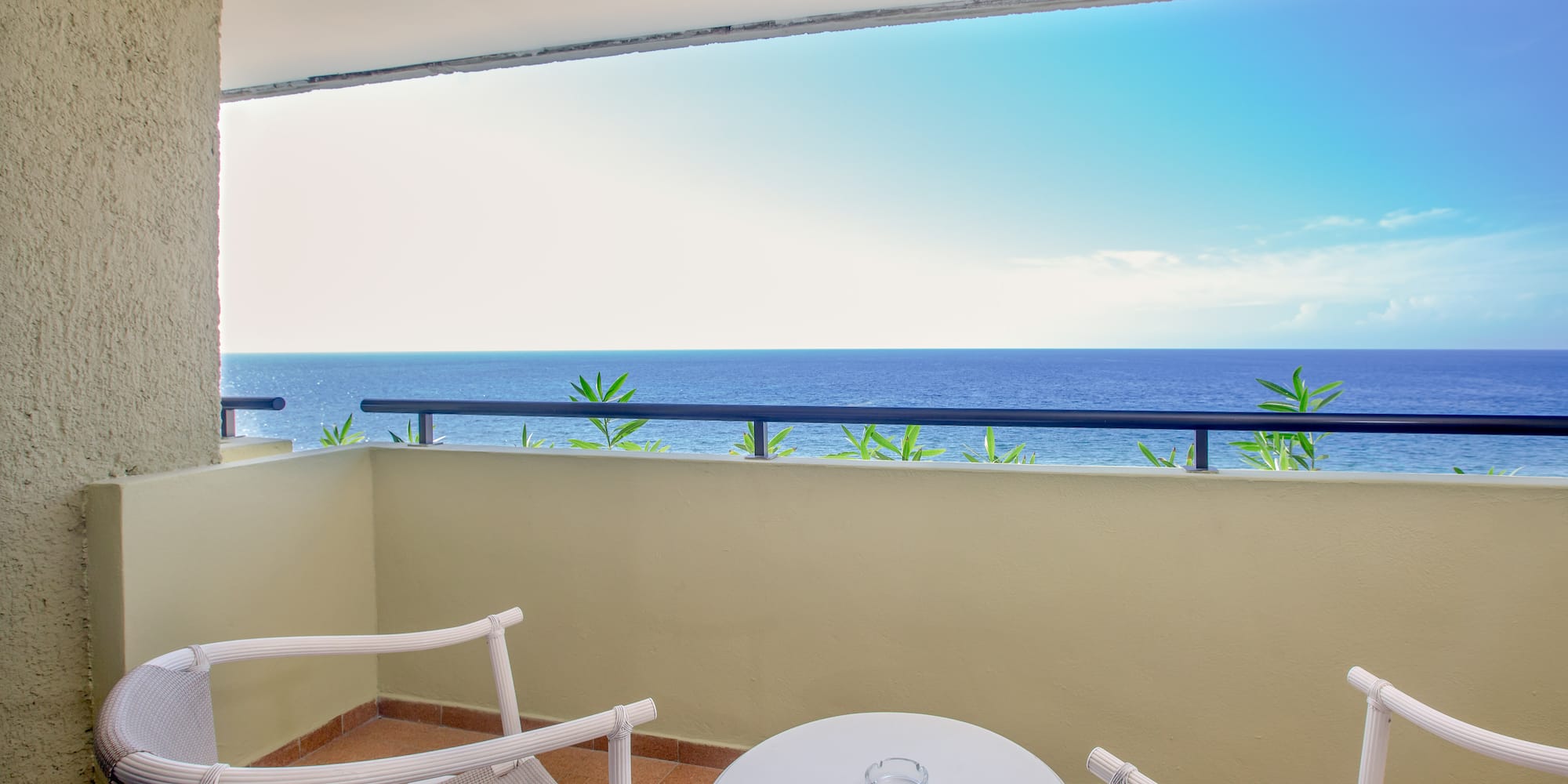 a balcony with a table and chairs overlooking the ocean