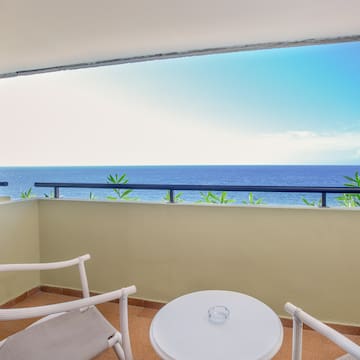 a balcony with a table and chairs overlooking the ocean