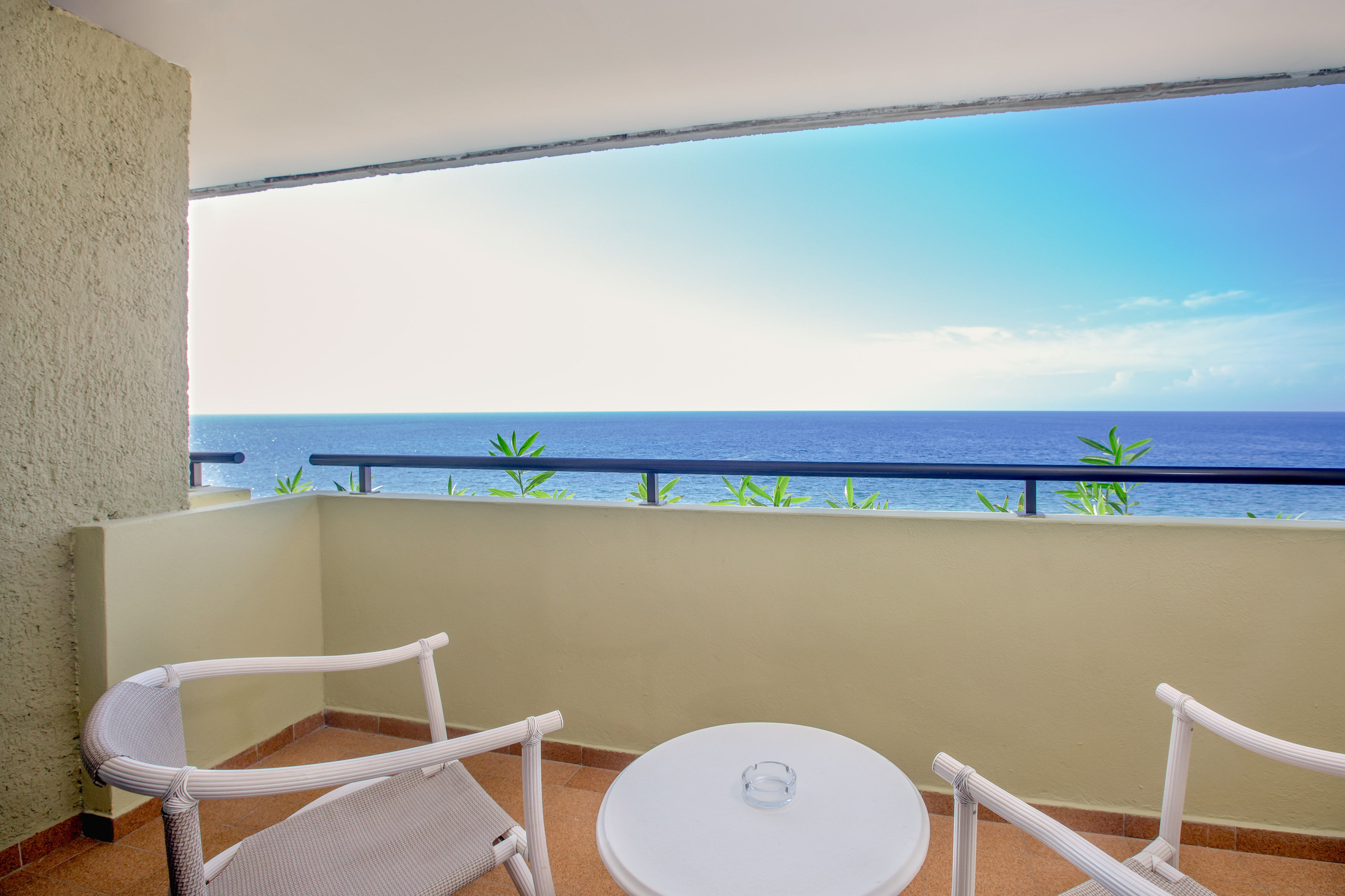 a balcony with a table and chairs overlooking the ocean