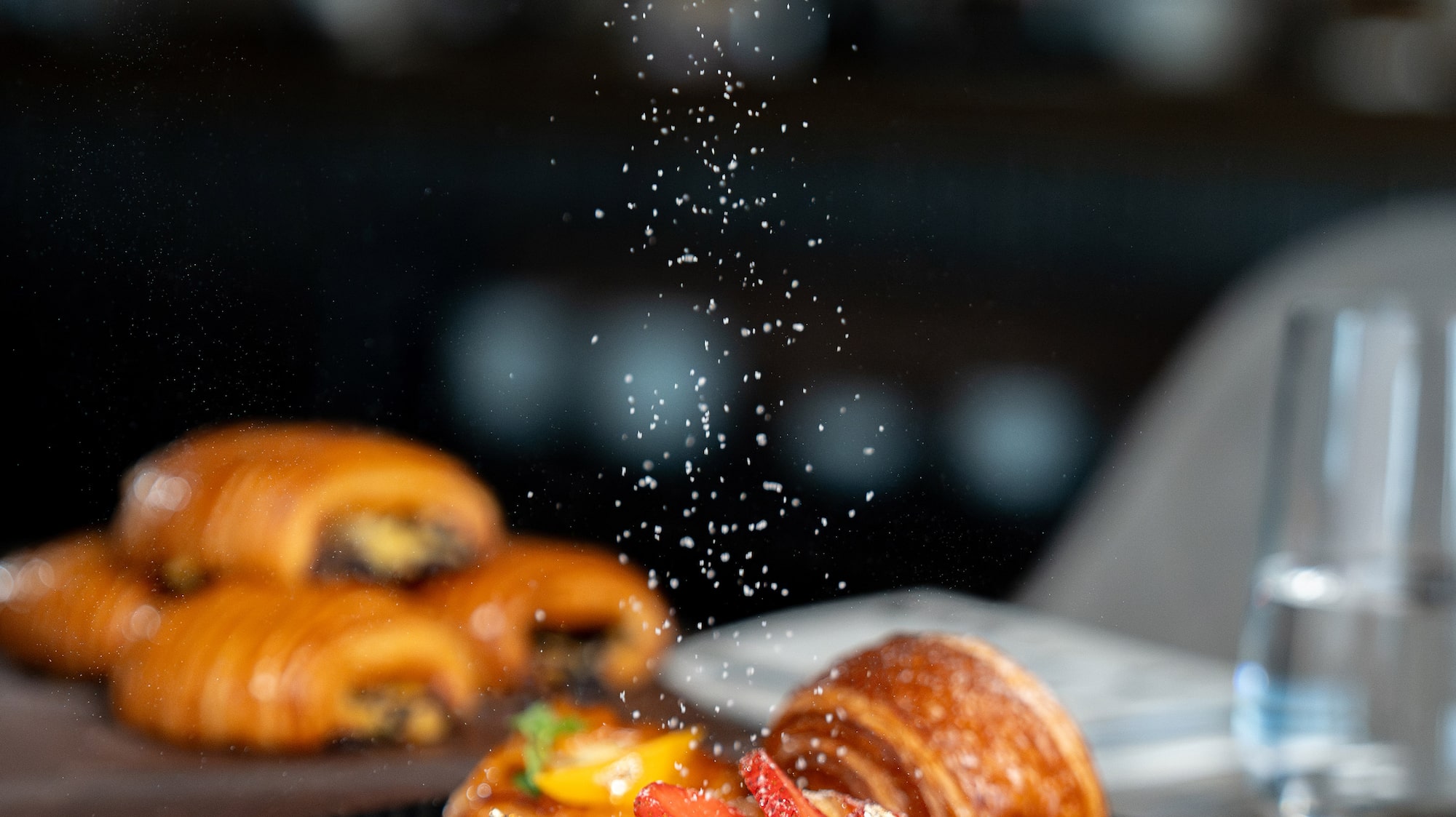 a plate of food with powdered sugar falling on it