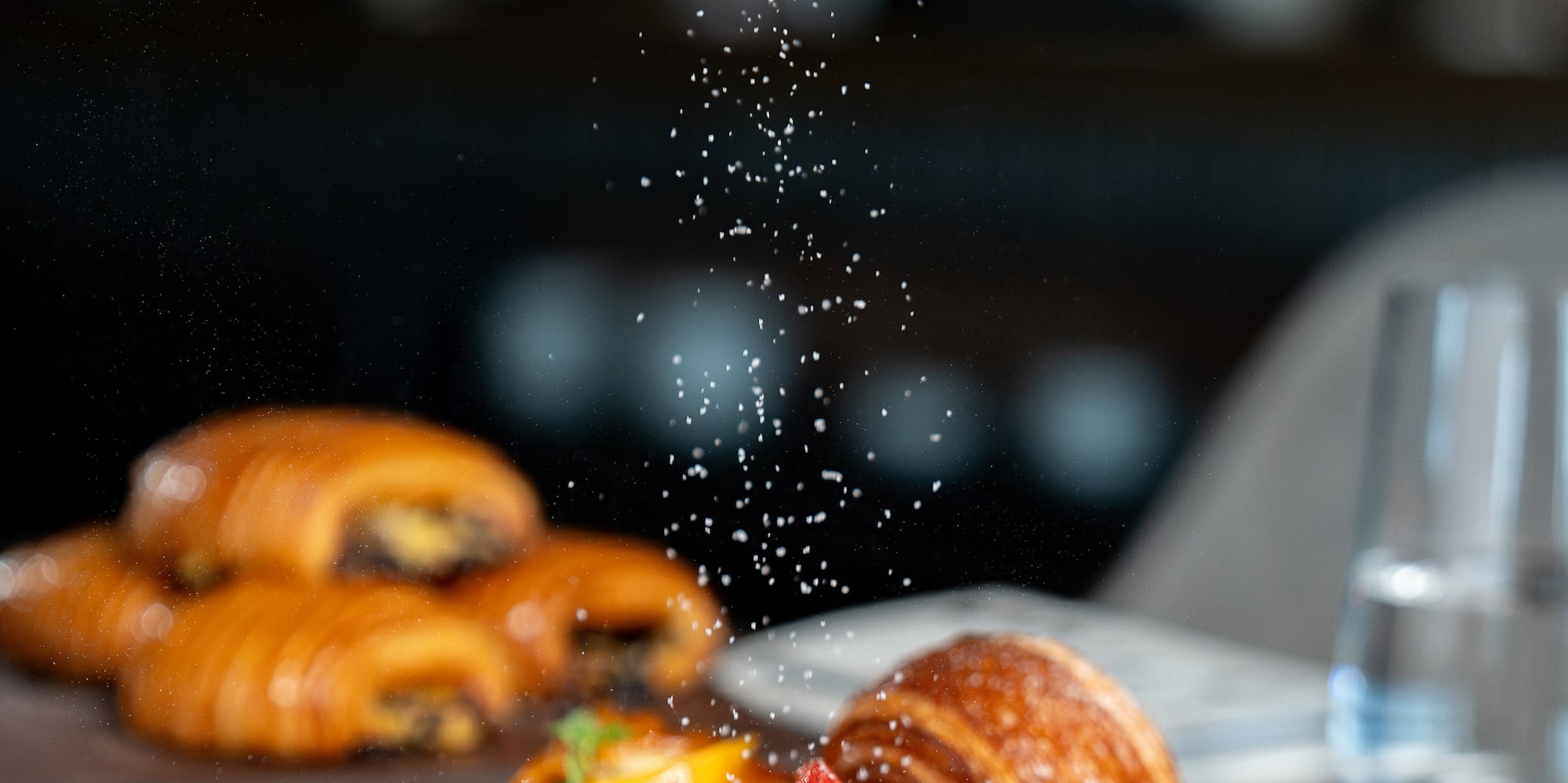 a plate of food with powdered sugar falling on it