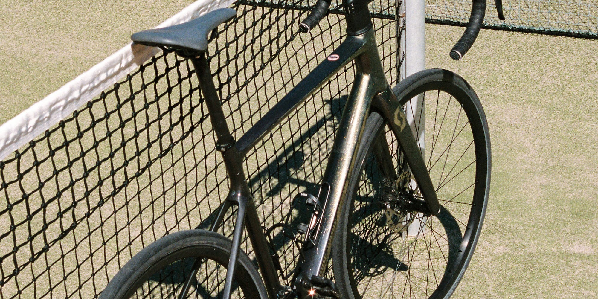 a bicycle leaning against a tennis net