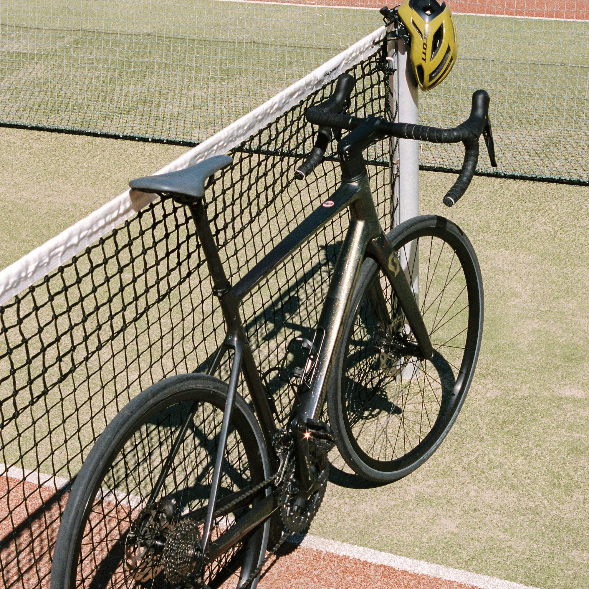 a bicycle leaning against a tennis net