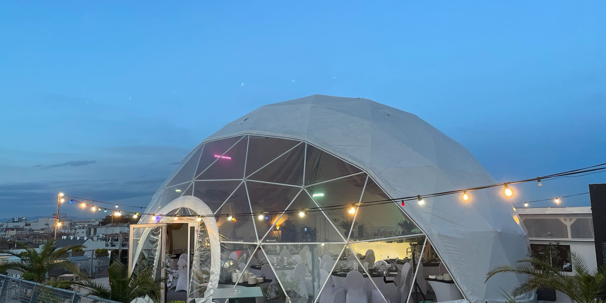 a dome tent with lights and a fence
