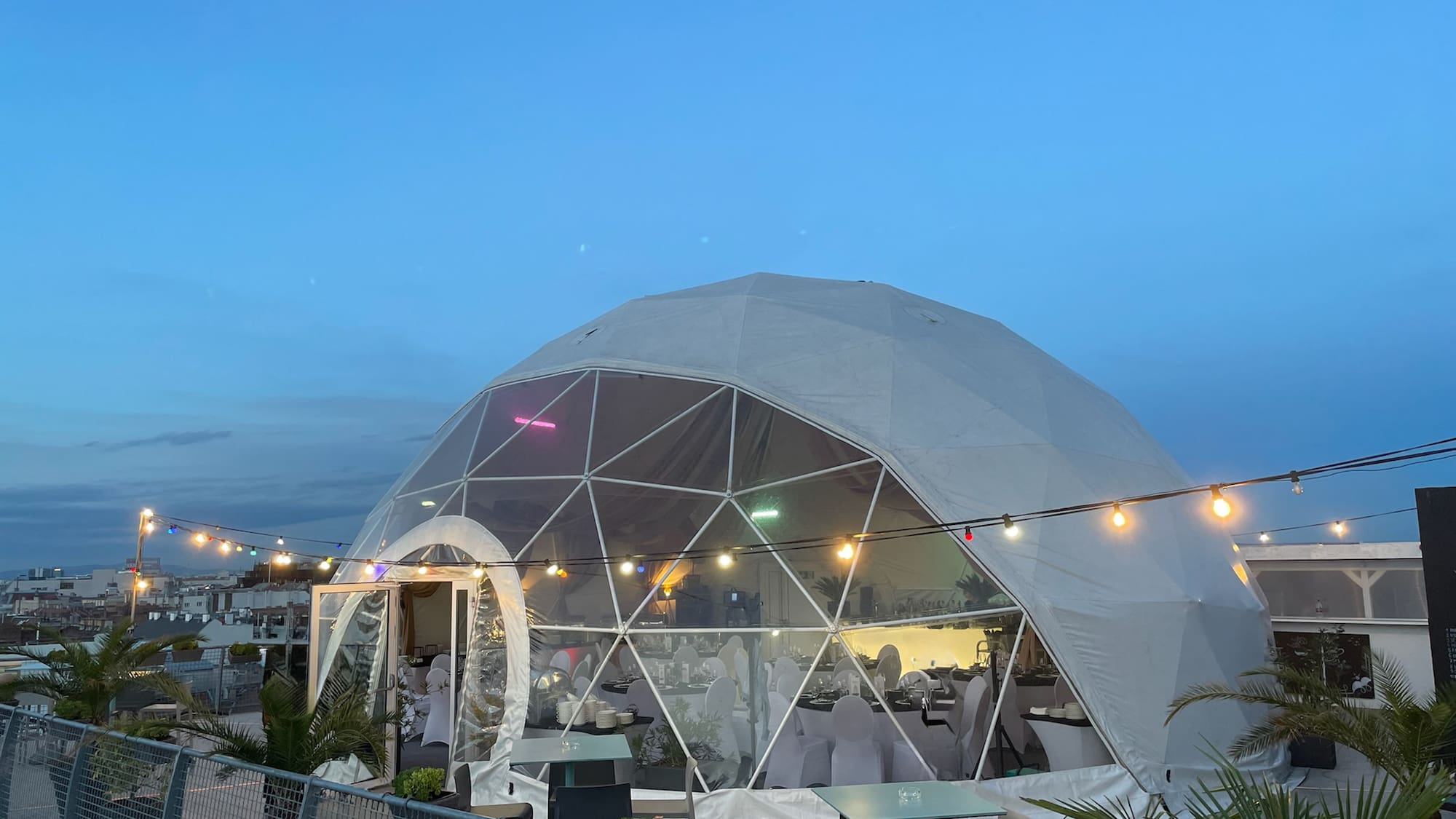 a dome tent with lights and a fence