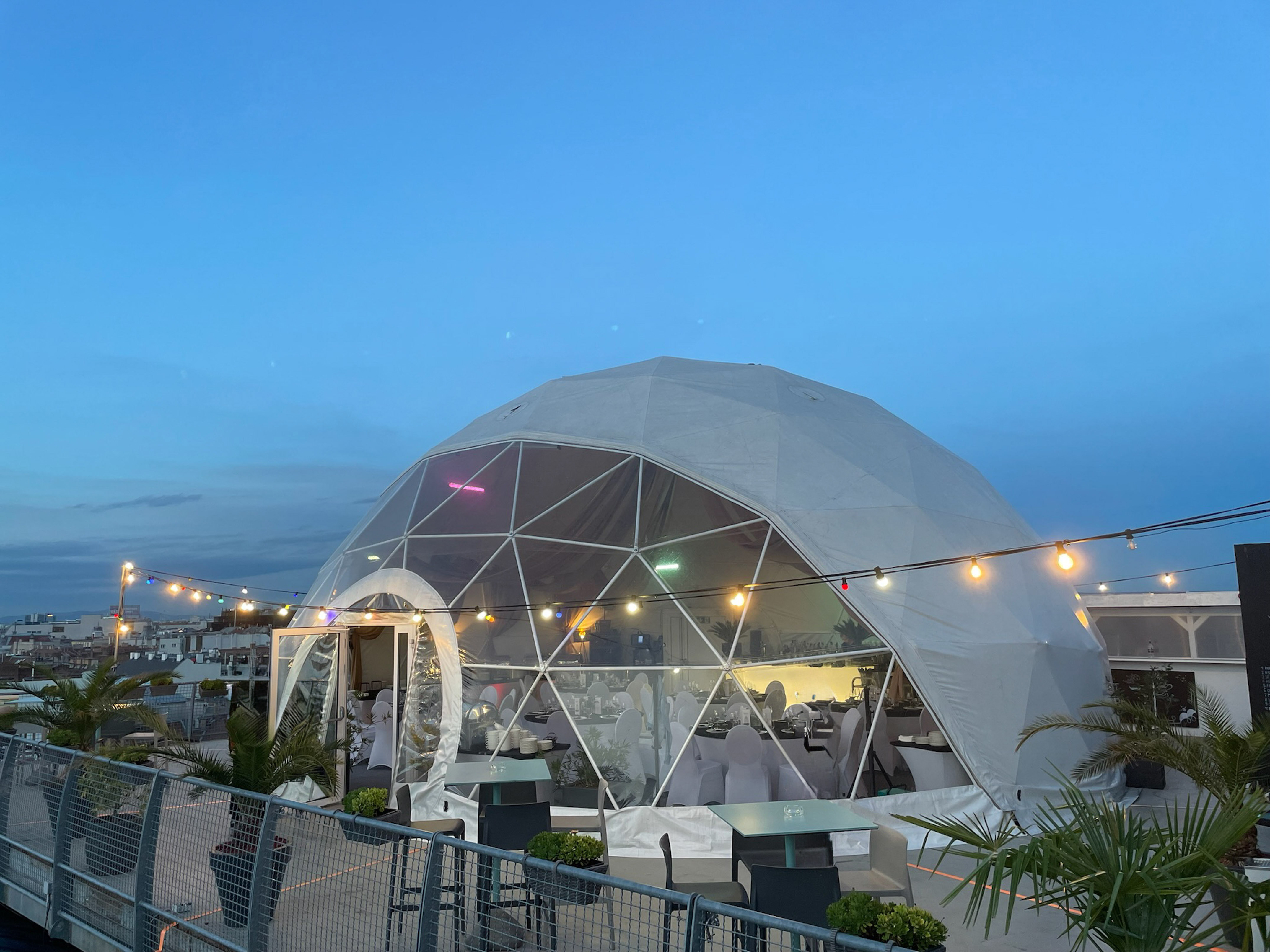 a dome tent with lights and a fence