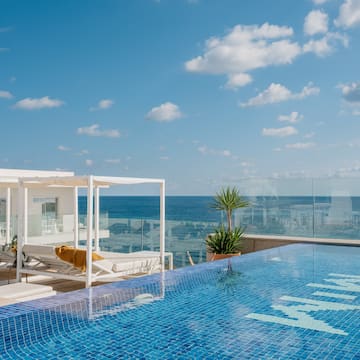 a pool and lounge chairs on a rooftop