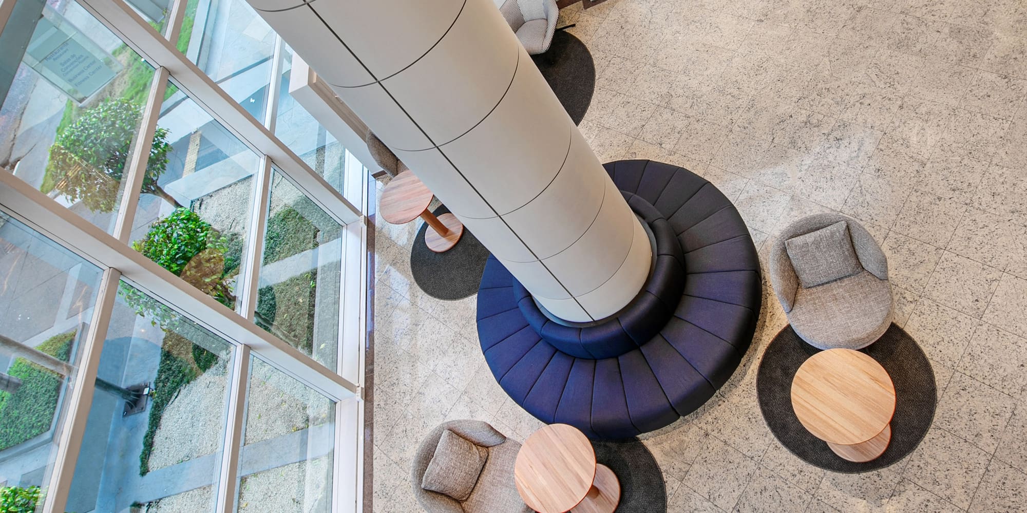 a room with a tall column and chairs