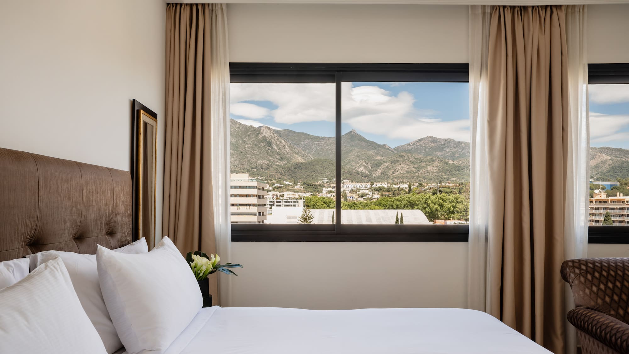 a bed with a view of mountains and trees