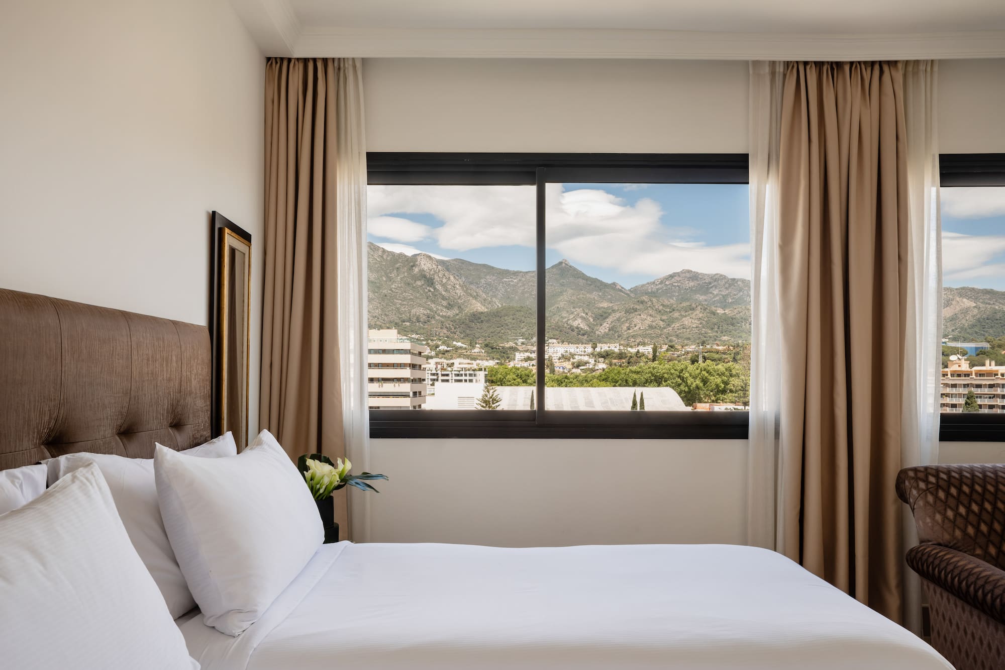 a bed with a view of mountains and trees