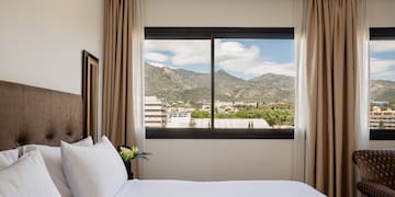 a bed with a view of mountains and trees