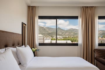 a bed with a view of mountains and trees