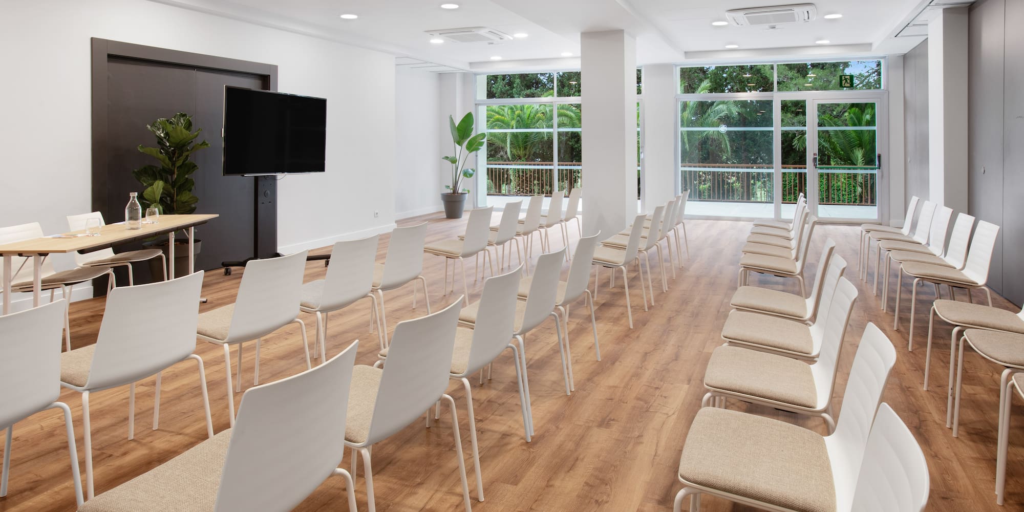 a room with white chairs and a wood floor