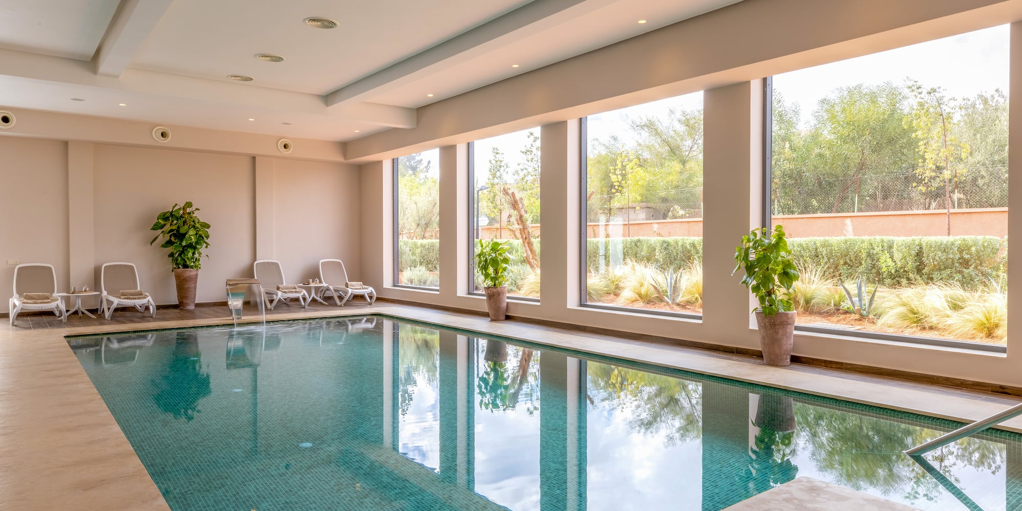a indoor pool with windows and plants