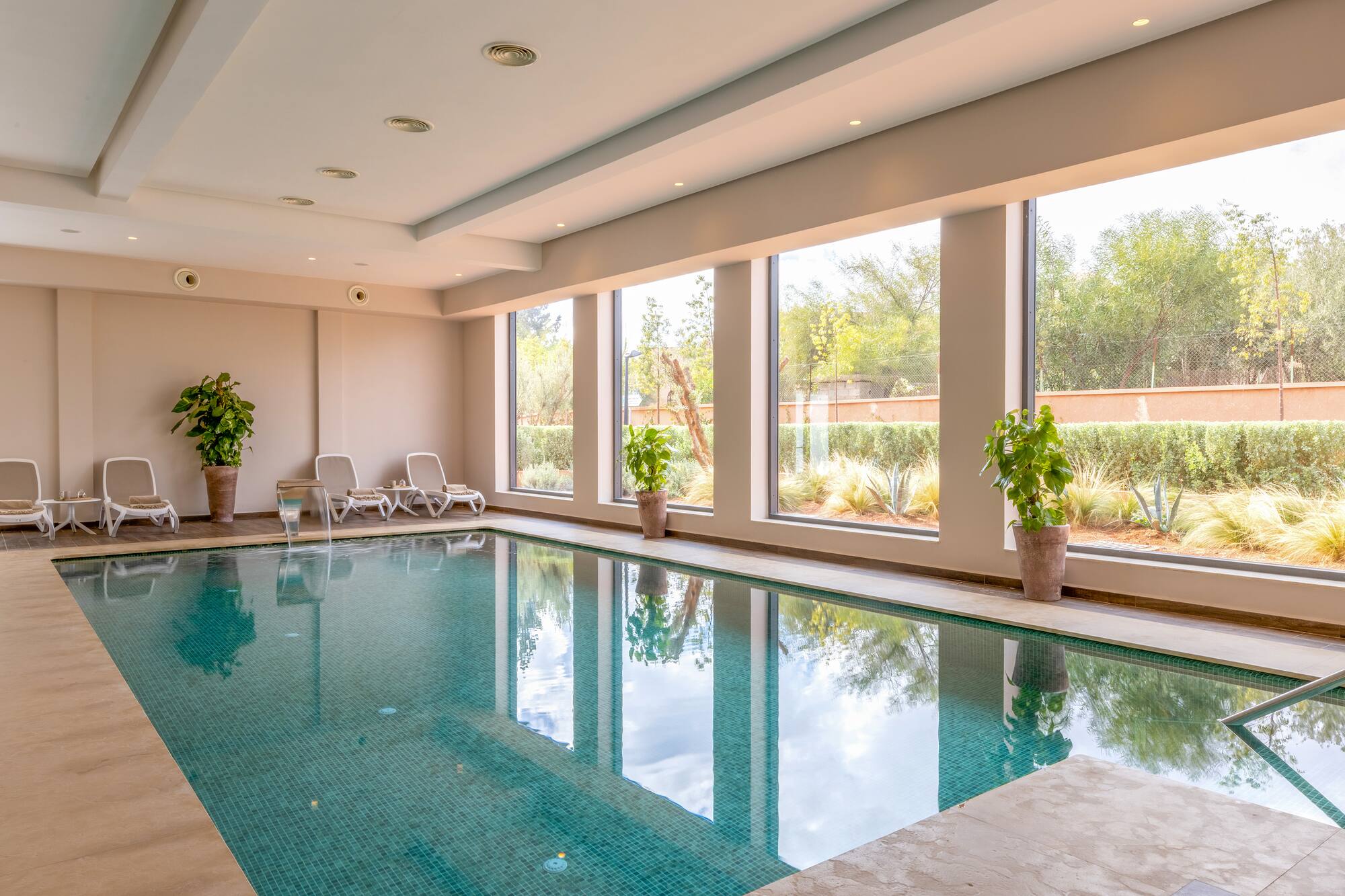 a indoor pool with windows and plants