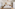 Hotel bedroom with king bed, wooden accents, closet, ceiling fan, and natural decor.