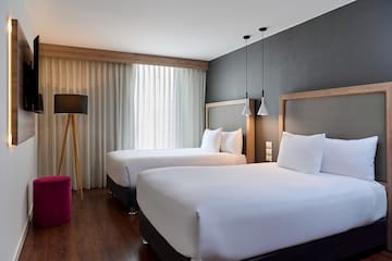 a room with two beds and a red stool