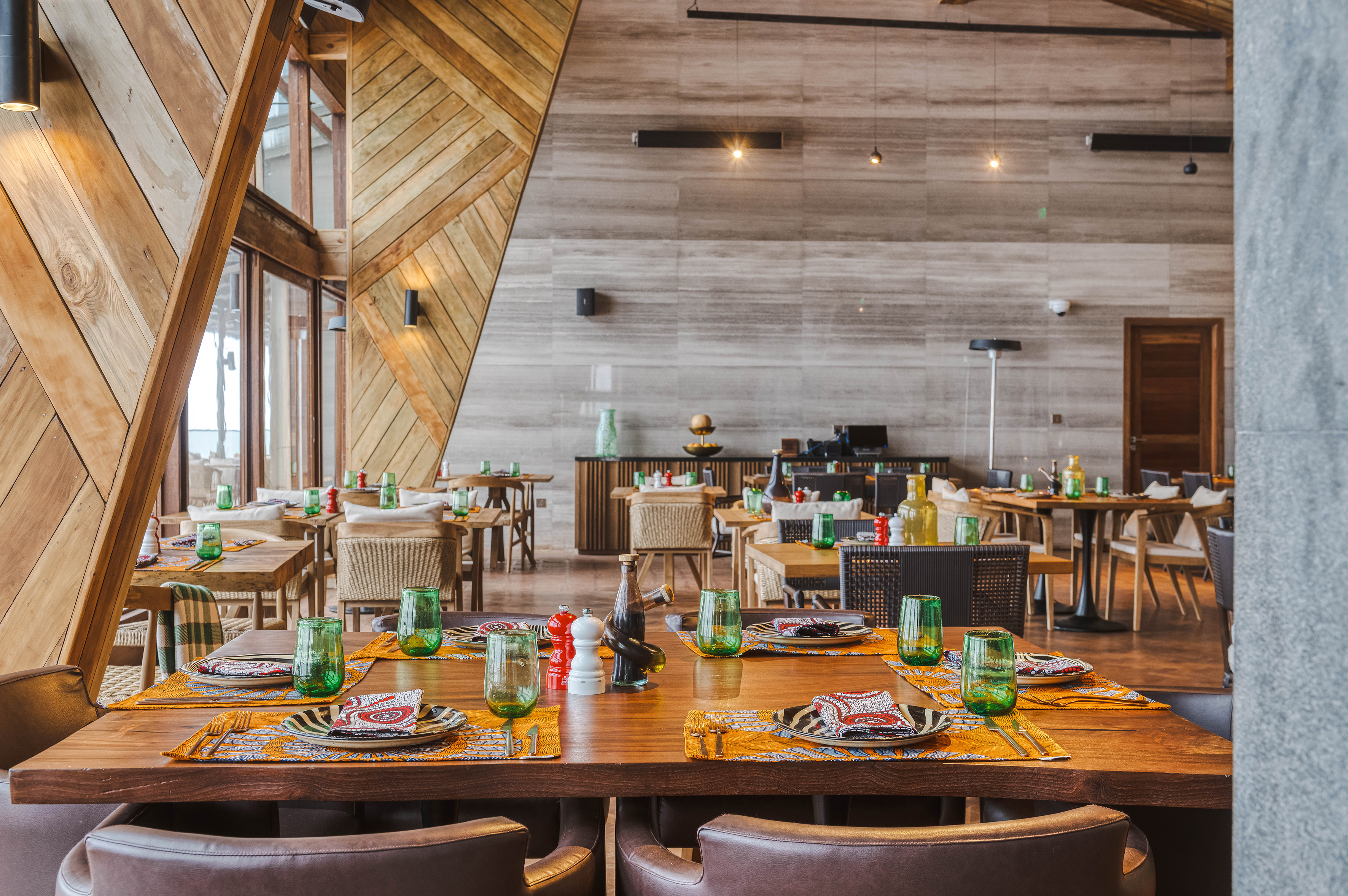 Stylish restaurant dining room with geometric wood walls and elegant table settings.
