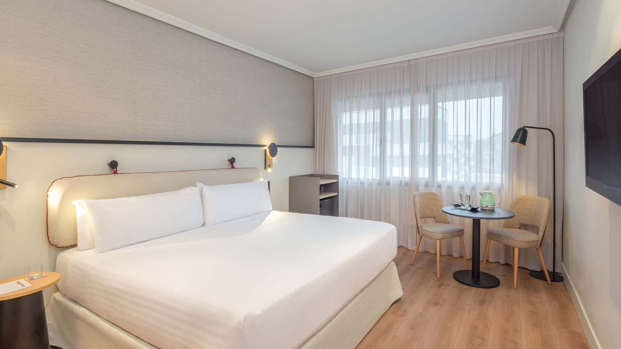 a room with a bed and chairs