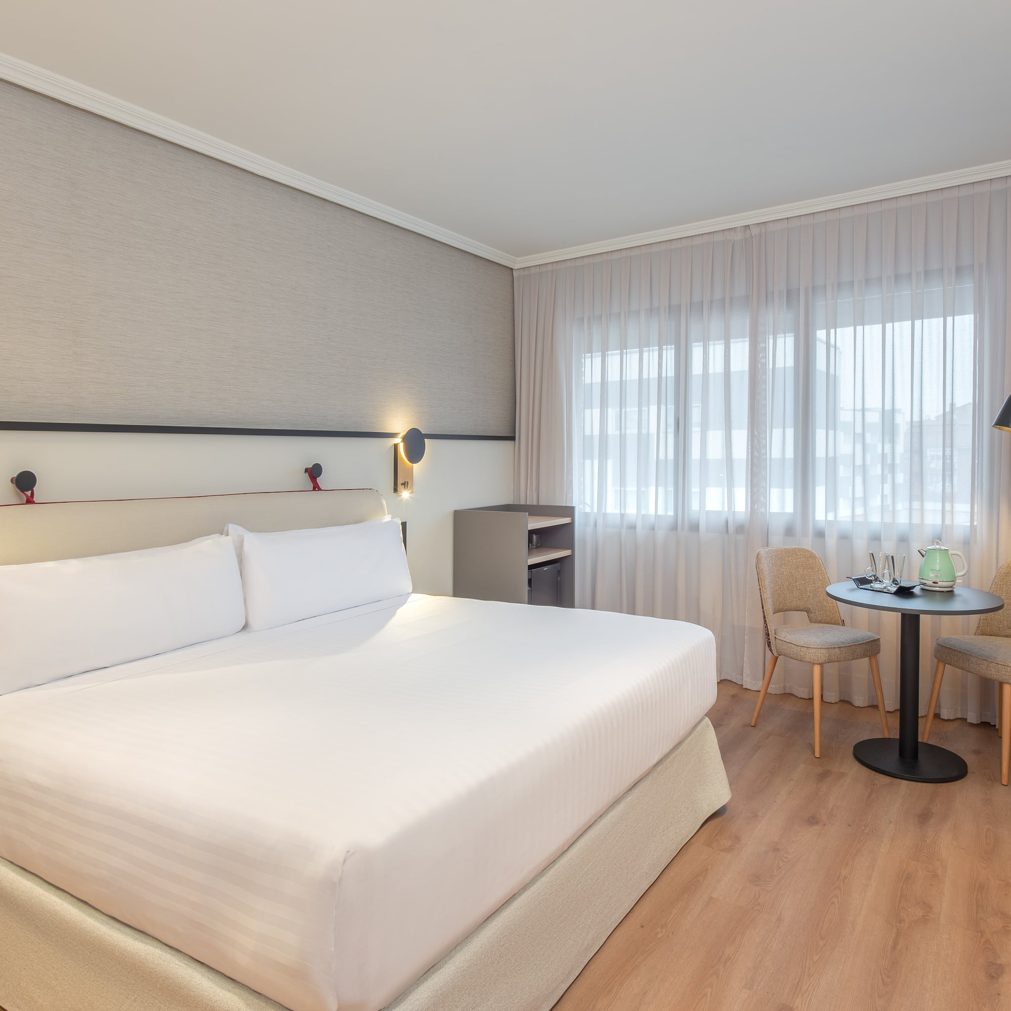 a room with a bed and chairs