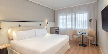 a room with a bed and chairs