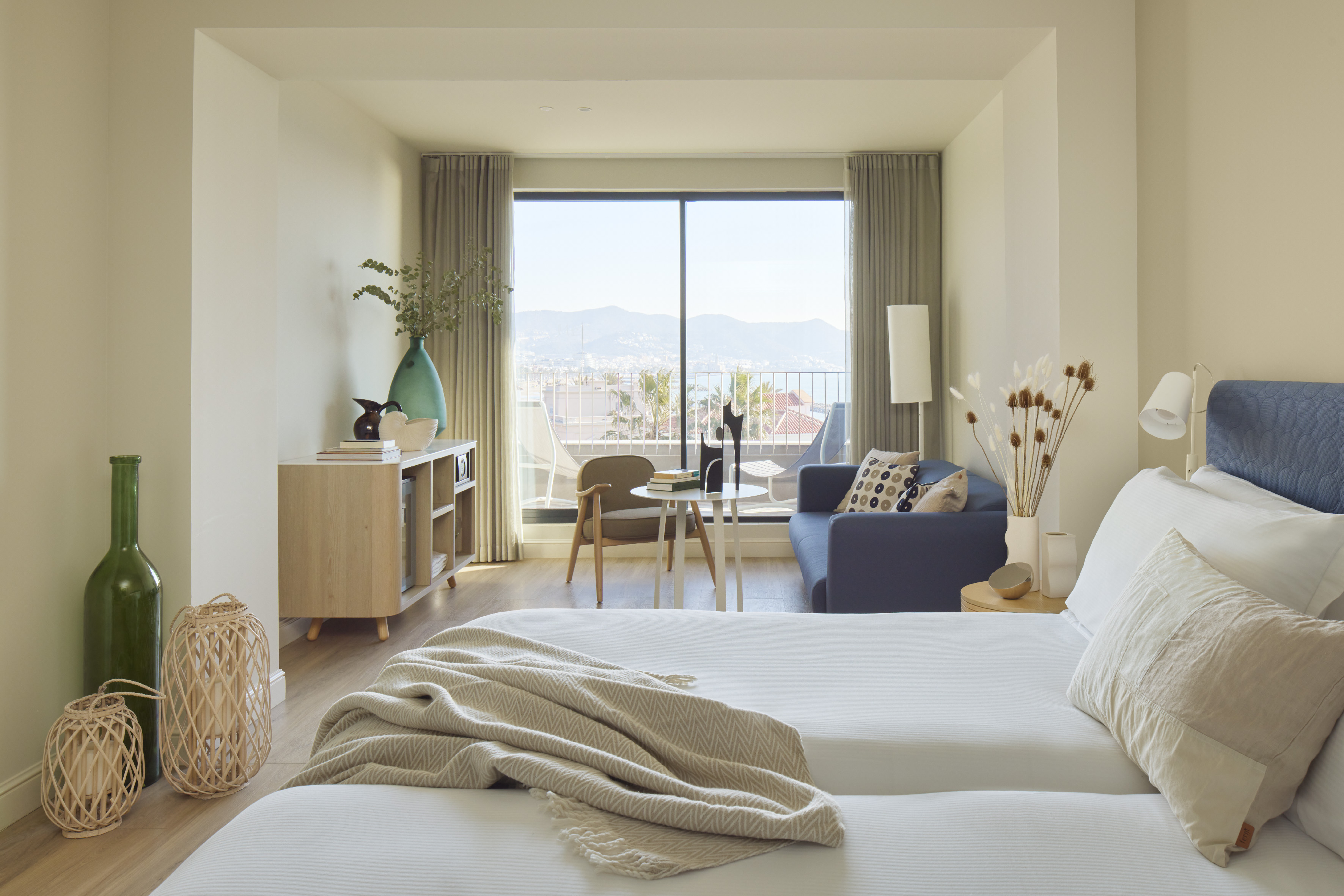 Modern hotel suite with balcony, mountain and city views.