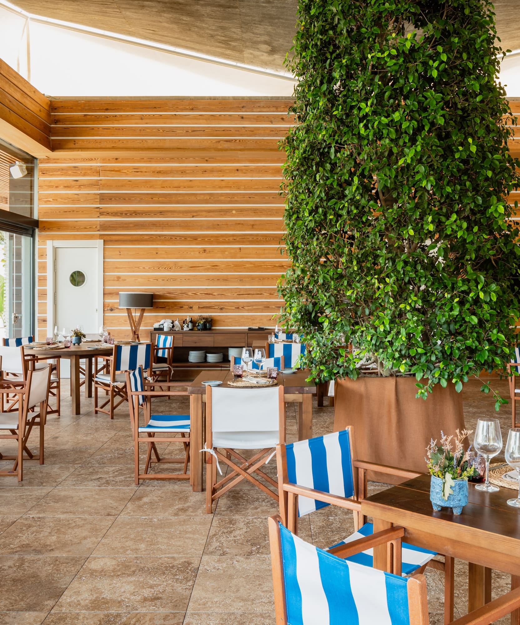 a room with tables and chairs and a tree