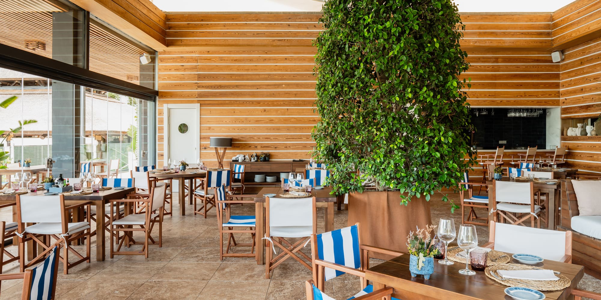 a room with tables and chairs and a tree