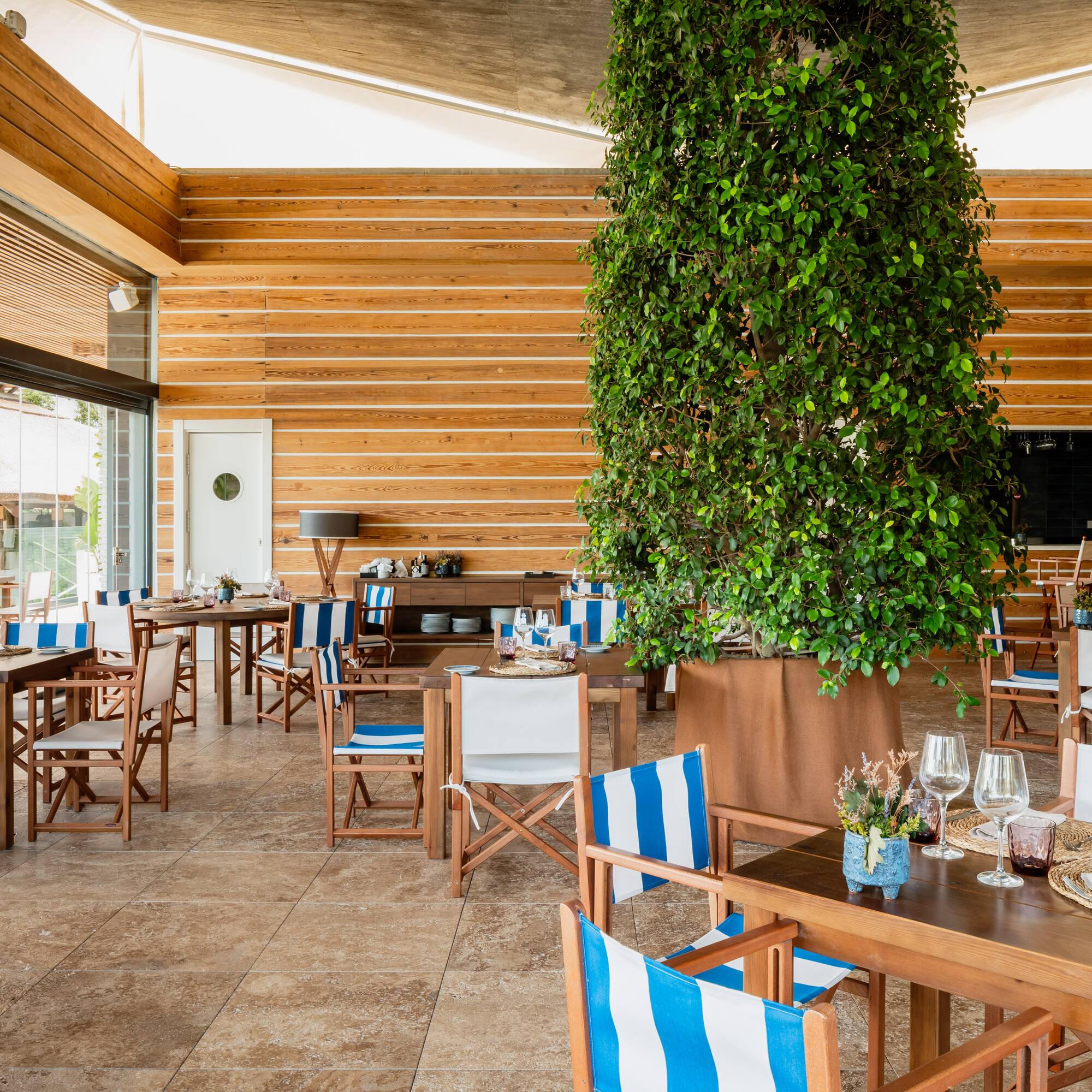 a room with tables and chairs and a tree