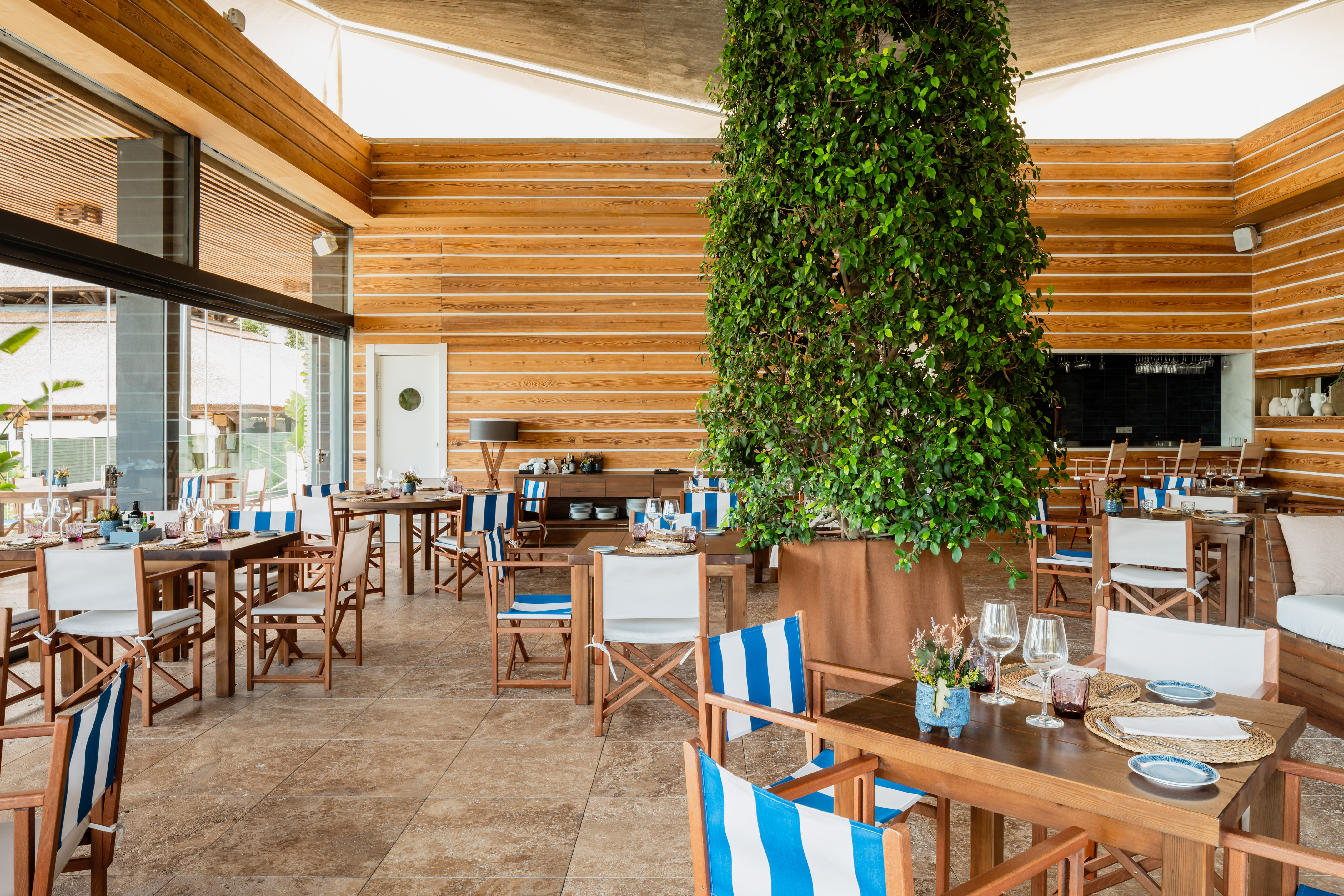 a room with tables and chairs and a tree