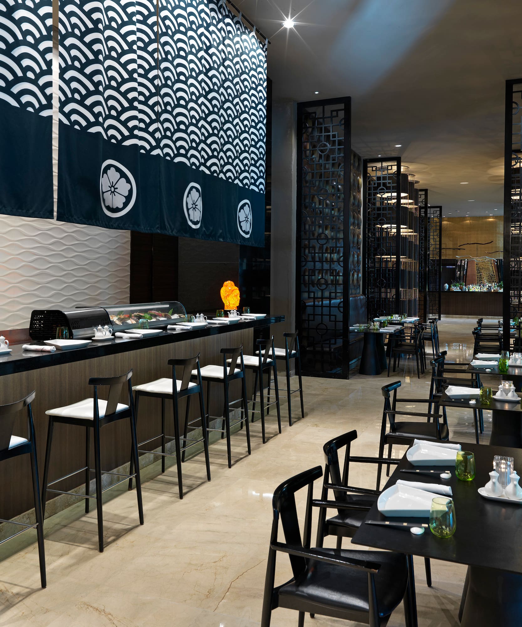 Modern Japanese restaurant with sushi bar, noren curtains, and dining tables.