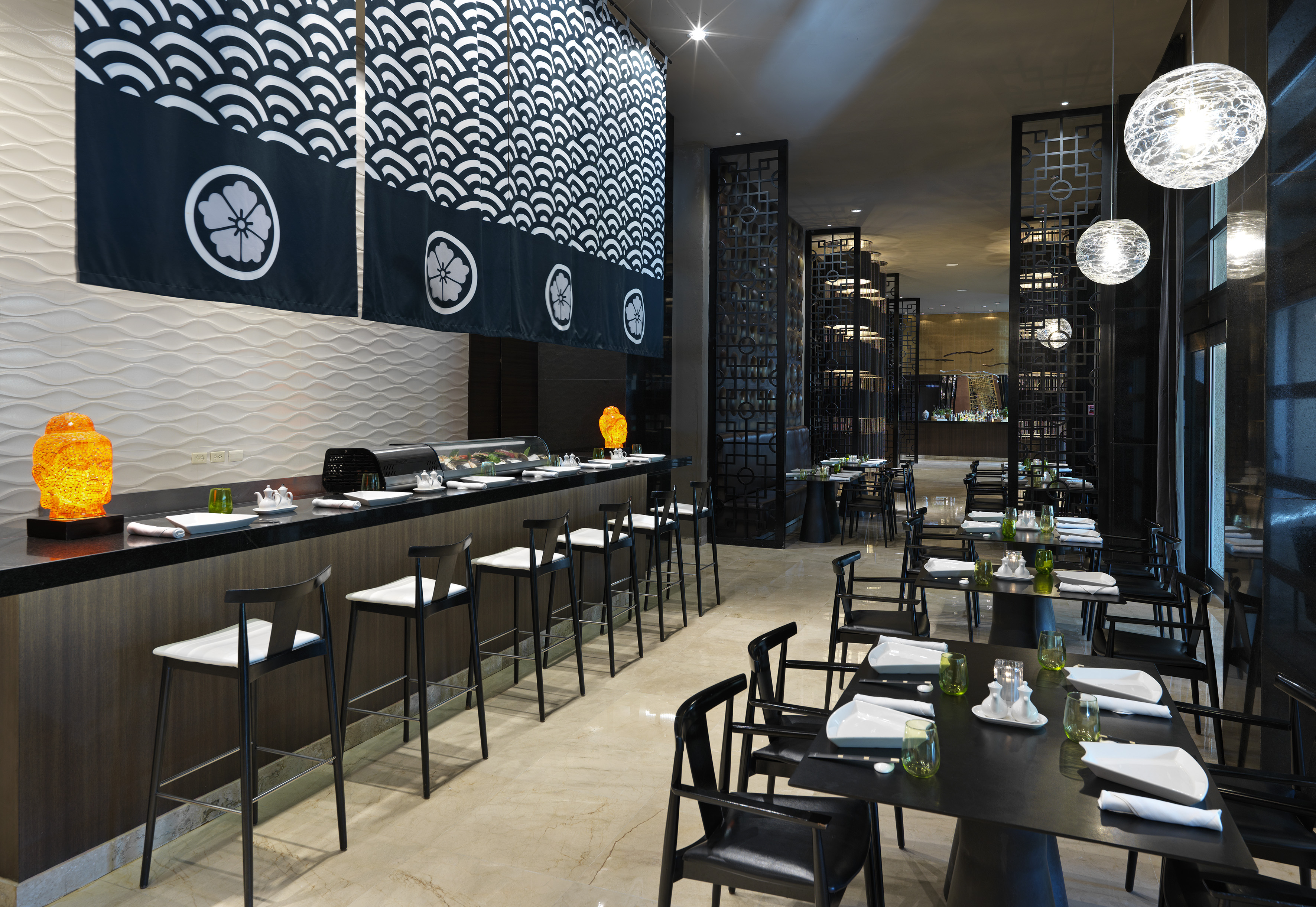 Modern Japanese restaurant with sushi bar, noren curtains, and dining tables.