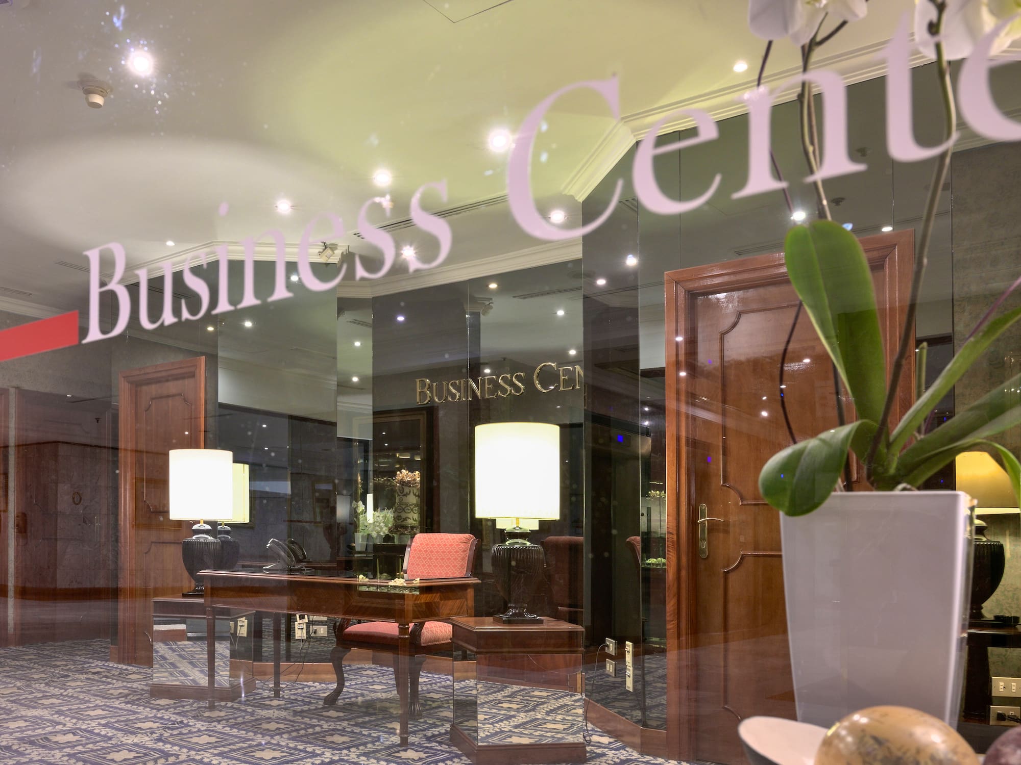 a glass window with a desk and a plant in front of it